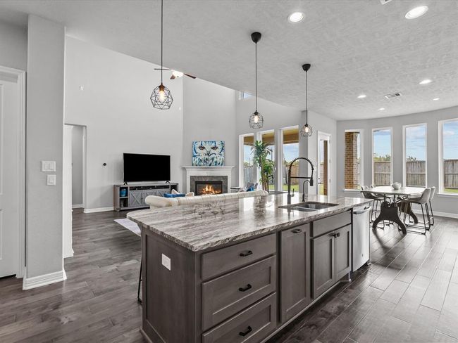 Chef's eat-in island kitchen features 42" cabinets with crown molding, under cabinet lighting, designer backsplash, stainless steel appliances and legthy countertops | Image 7