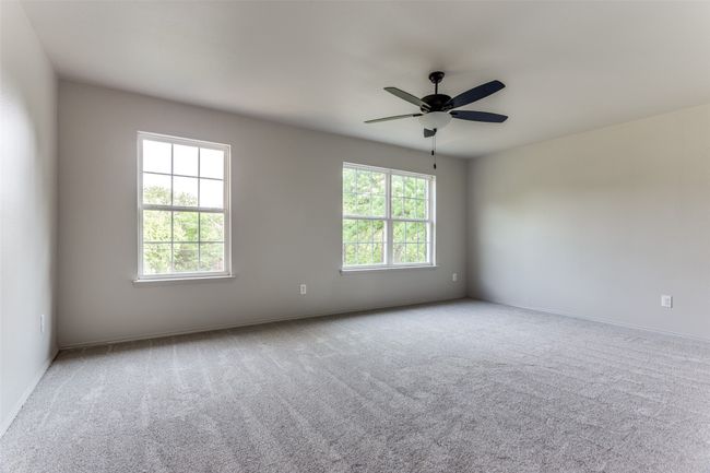 Carpeted empty room with a ceiling fan and baseboards | Image 36