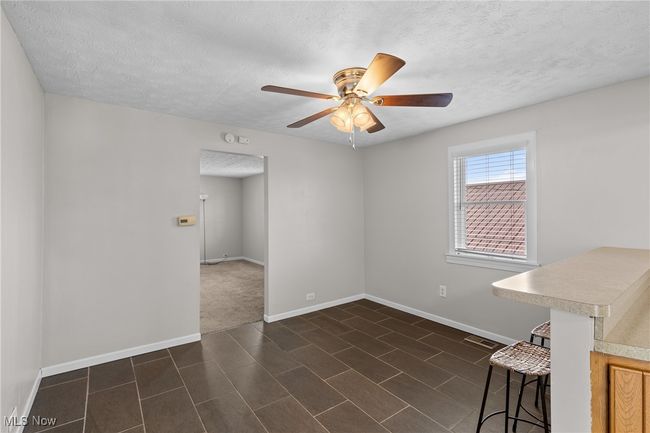 Empty room with baseboards, ceiling fan, and a textured ceiling | Image 9