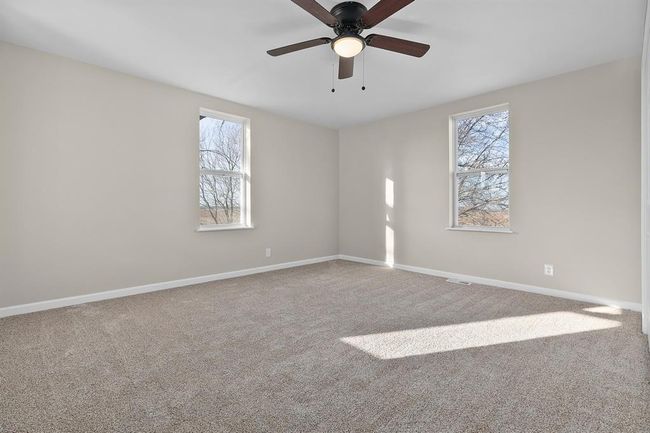 Carpeted spare room featuring healthy amount of natural light, ceiling fan, and baseboards | Image 16