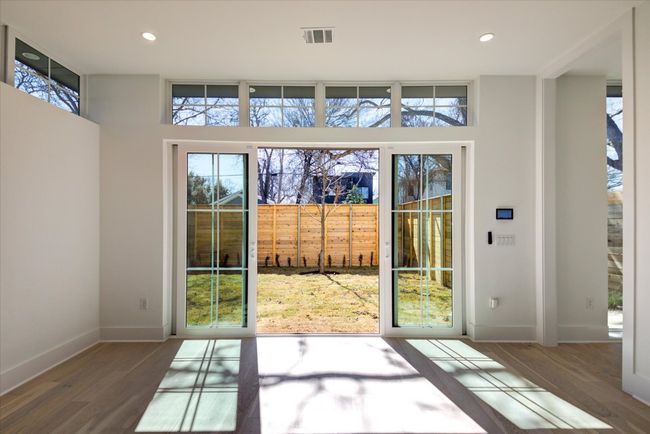 The living room's sliding glass doors open to the fenced front yard, another place a pool could be added, as it is completely private from the street. | Image 16