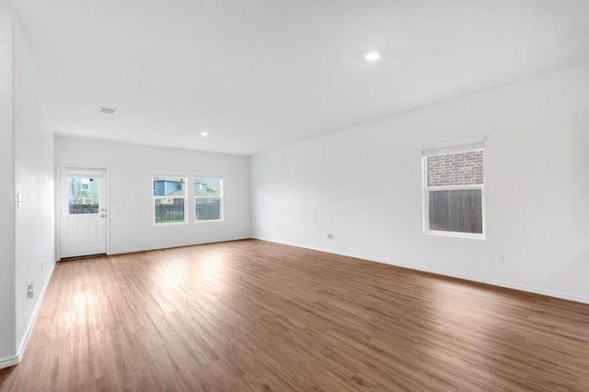 Unfurnished living room featuring baseboards, wood finished floors, and recessed lighting | Image 8