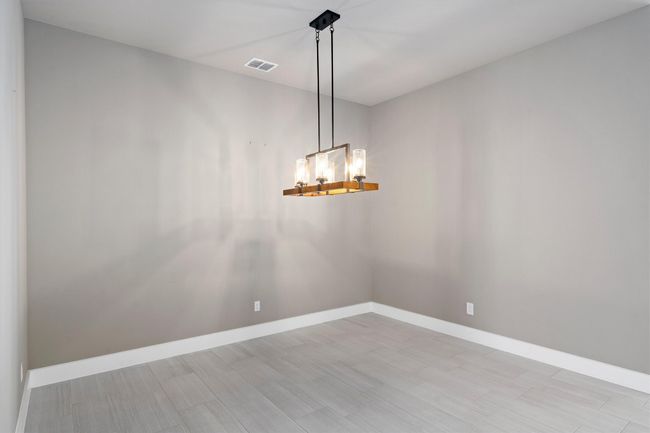 Spare room with a chandelier and wood finished floors | Image 11