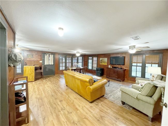 Living area featuring visible vents, ceiling fan, light wood-type flooring, and plenty of natural light | Image 7