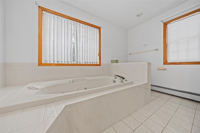 Full bathroom with a baseboard radiator, tile patterned floors, and a whirlpool tub | Image 28