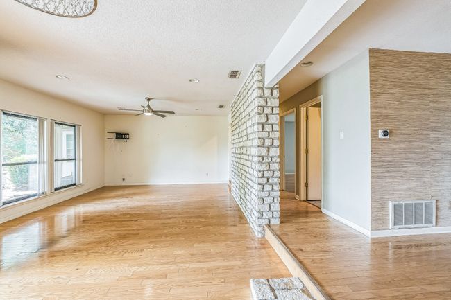 Spare room featuring light wood finished floors, a textured ceiling, visible vents, and ceiling fan | Image 10