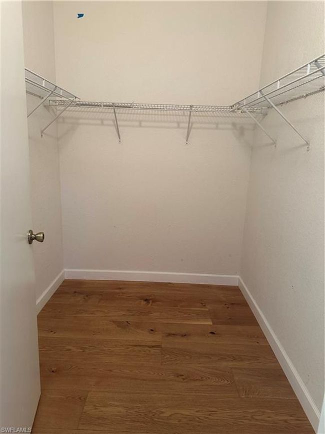 Walk in closet with dark wood-type flooring | Image 12