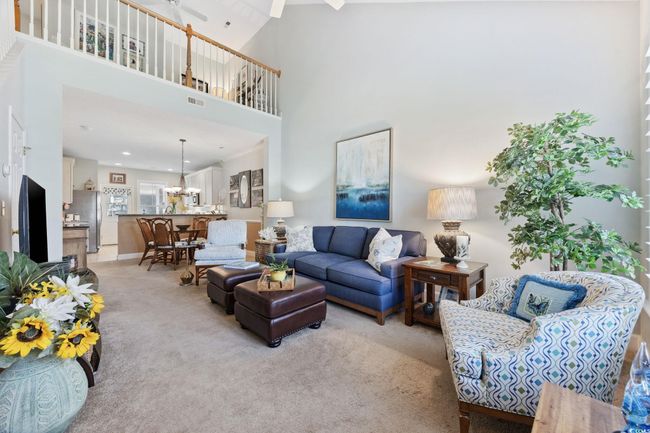 Living room featuring light colored carpet, a towering ceiling, and a ceiling fan | Image 5