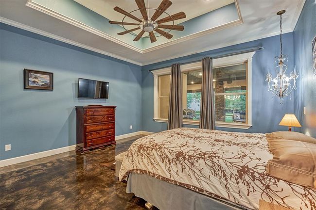 Three large windows offer a clear view of the screened-in back porch and the peaceful green space beyond, bringing in natural light and showcasing the home’s tranquil surroundings. | Image 28
