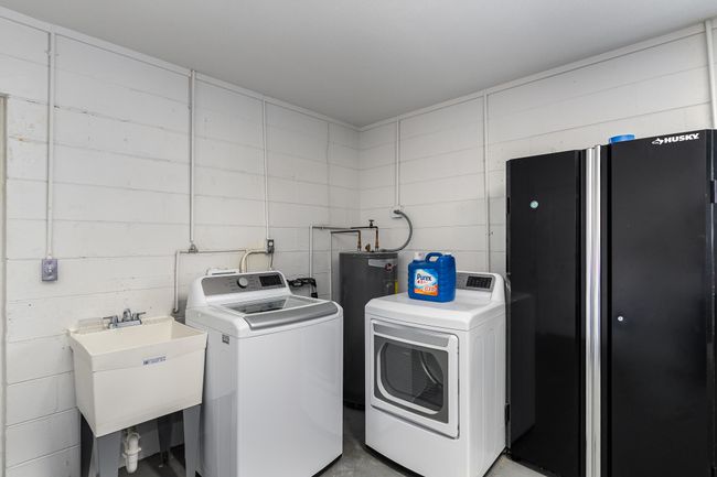 Laundry in the garage with a utility sink | Image 24