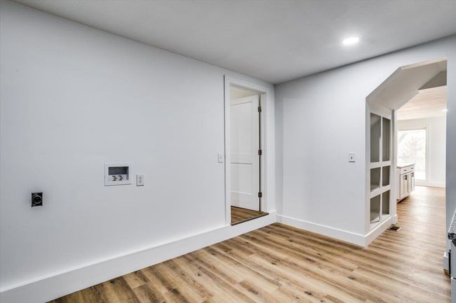 Laundry room featuring laundry area, hookup for a washing machine, electric dryer hookup, light wood-style flooring, and baseboards | Image 14