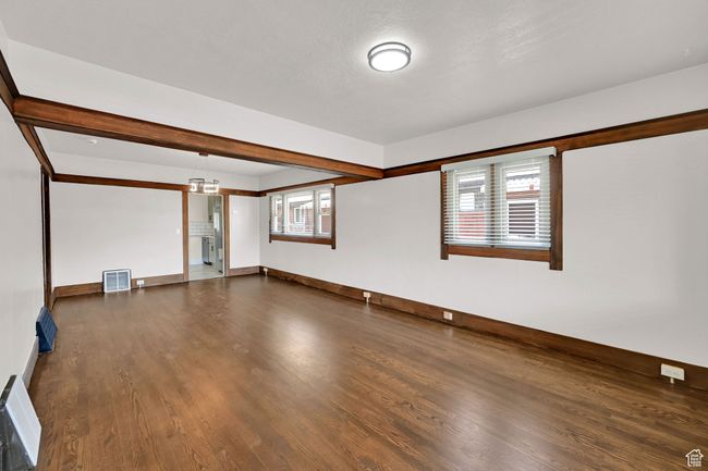 Unfurnished room with dark wood-style floors and baseboards | Image 4