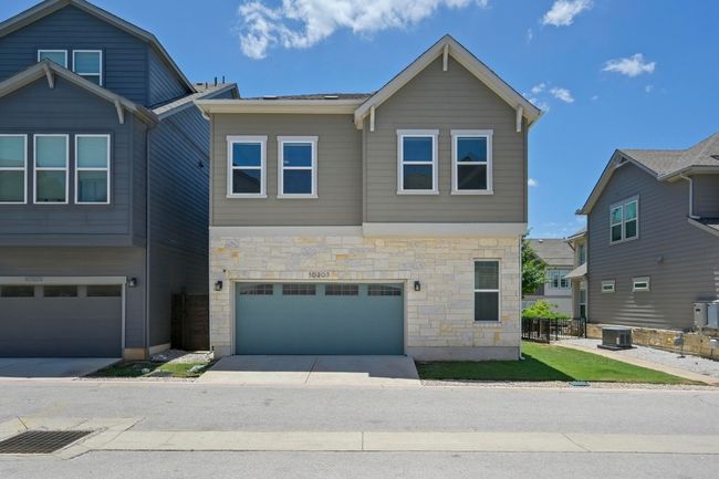 View of front facade with stone siding, an attached garage, and driveway | Image 30