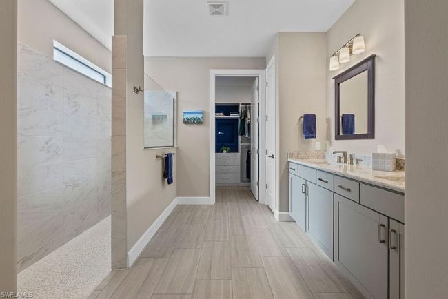 Full bath with vanity, baseboards, visible vents, walk in shower, and a walk in closet | Image 22