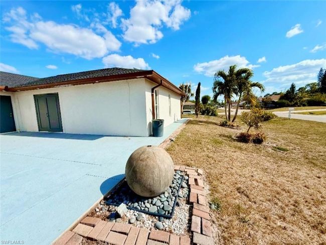View of side of home featuring a lawn, stucco siding, and a patio area | Image 28