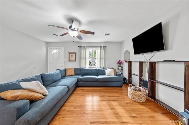 Living room with light wood finished floors and a ceiling fan | Image 10