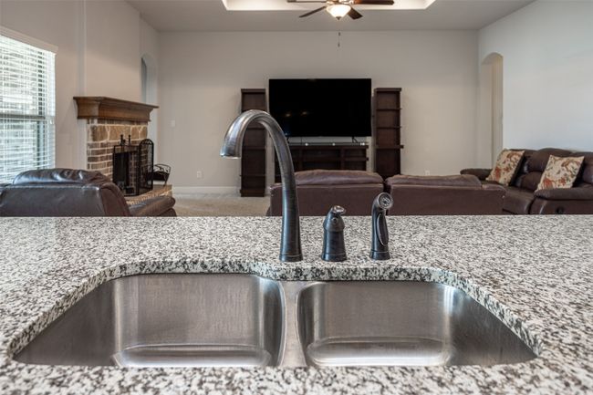 Detailed view of ceiling fan, carpet, a fireplace, and arched walkways | Image 21