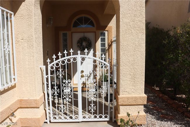 Property entrance with stucco siding and a gate | Image 12