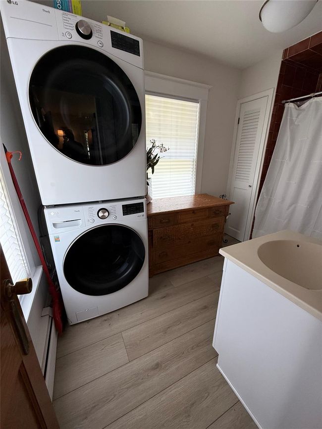 Main floor bathroom with stacked washing machine and dryer. | Image 14