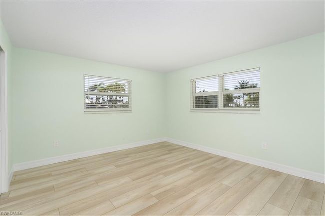 Bedroom with baseboards, vinyl wood finished floors, and a healthy amount of sunlight | Image 14