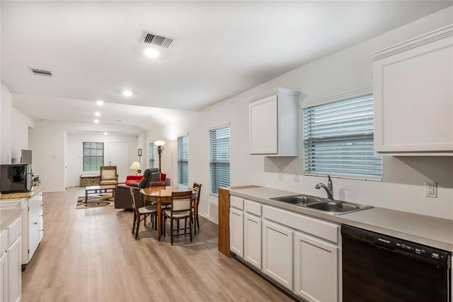 Additional kitchen angle highlighting the dining area, through to the living area. | Image 10