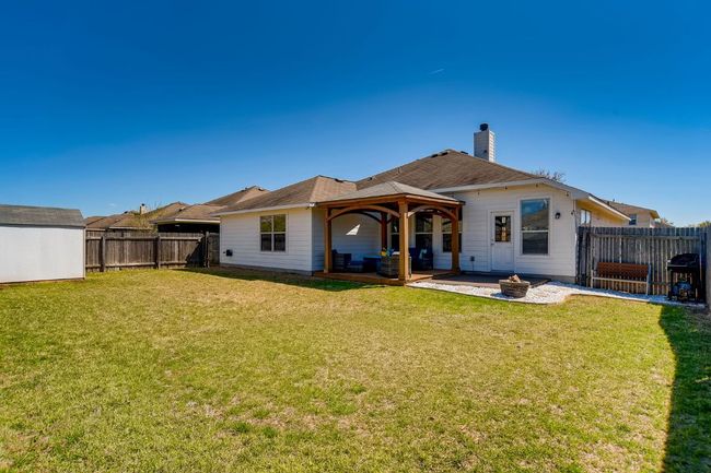 Back of house with a gazebo, an outdoor fire pit, a patio area, a fenced backyard, and a chimney | Image 26
