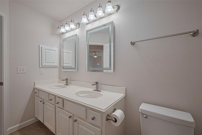 Upstairs bathroom features a tub/shower combo and lighted vanity mirrors for a modern, functional touch. | Image 35