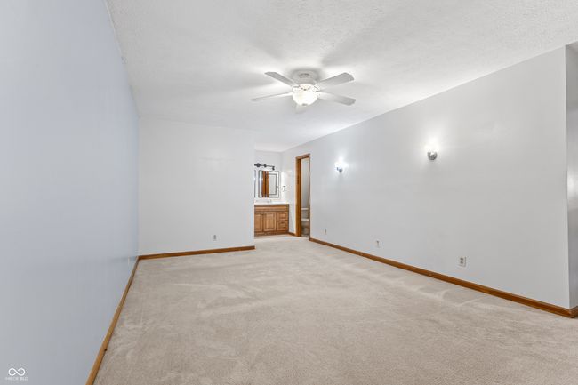 empty room featuring a ceiling fan, baseboards, light colored carpet, and a textured ceiling | Image 27