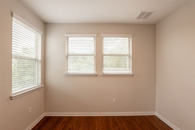 Unfurnished room featuring a wealth of natural light, dark wood-type flooring, and visible vents | Image 19