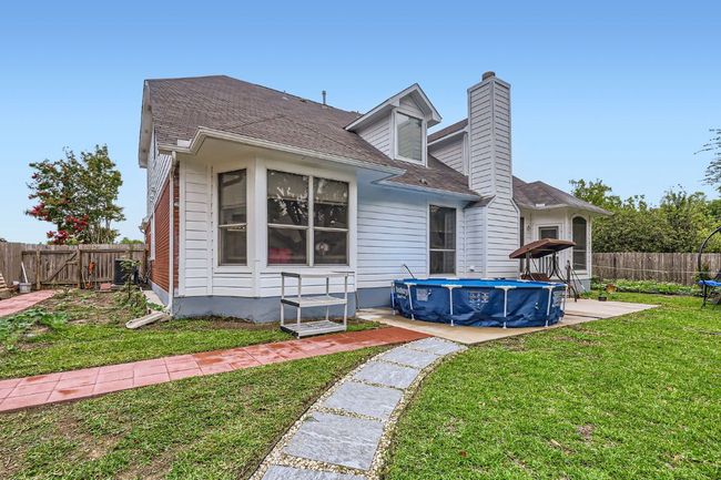Back of house with a fenced backyard, a chimney, and roof with shingles | Image 28