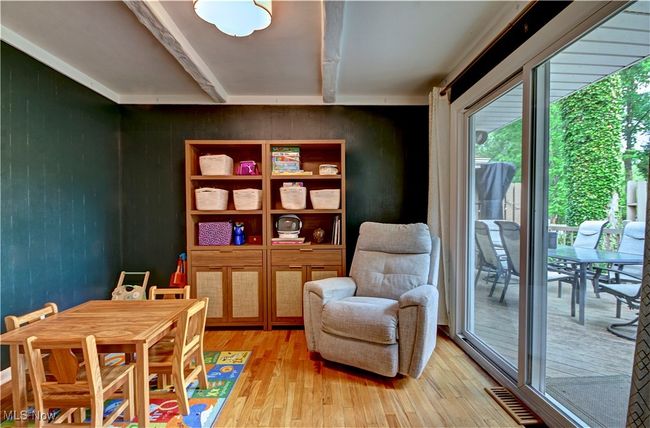 Sitting room featuring light wood finished floors, beam ceiling, and wooden walls | Image 13