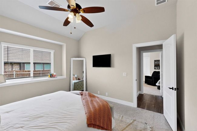 Carpeted bedroom with baseboards, vaulted ceiling, and ceiling fan | Image 26