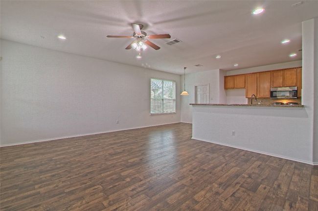 Unfurnished living room with dark wood finished floors, ceiling fan, and recessed lighting | Image 8