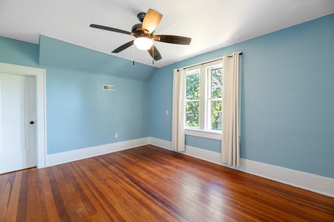 Empty room with lofted ceiling, baseboards, wood-type flooring, and ceiling fan | Image 28