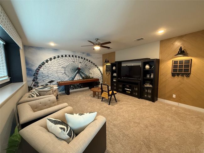 Living room with carpet flooring, ceiling fan, and wood walls | Image 18