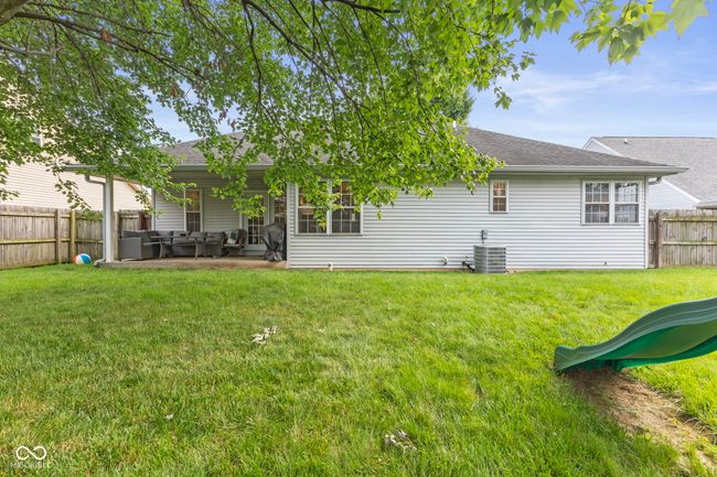 back of house with an outdoor hangout area, a shingled roof, a fenced backyard, and a patio | Image 34
