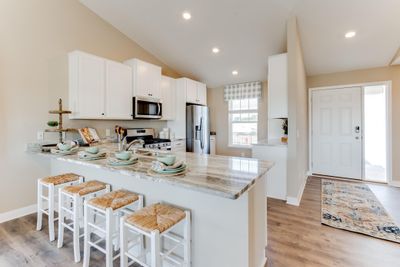 This functional kitchen boasts 42' cabinets with hardware, stainless steel appliances and quartz countertops. Photo is of model home. Colors and options may vary. Ask Sales Agent for details. | Image 1