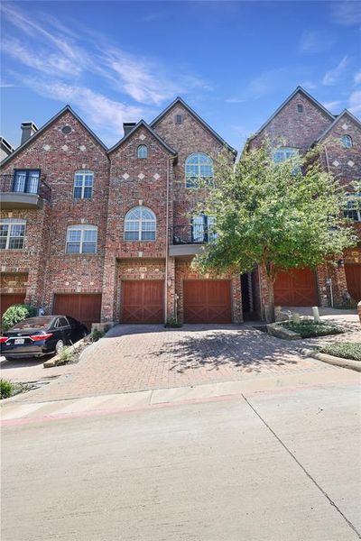 View of front of house featuring a garage and a tree next to the entry. | Image 2