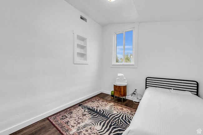 Bedroom featuring dark wood-style floors, baseboards, and vaulted ceiling | Image 12