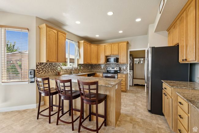 Kitchen with appliances with stainless steel finishes, a peninsula, plenty of natural light, backsplash, and recessed lighting | Image 14
