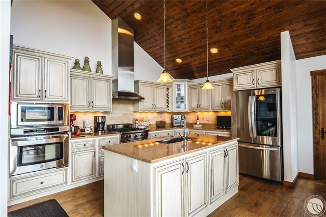 Chefs kitchen with double ovens, Wolf Range, and stunning counters | Image 13