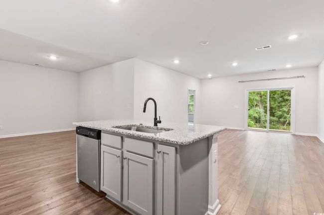 Kitchen featuring dishwasher, open floor plan, gray cabinetry, light wood-style floors, and a kitchen island with sink | Image 37