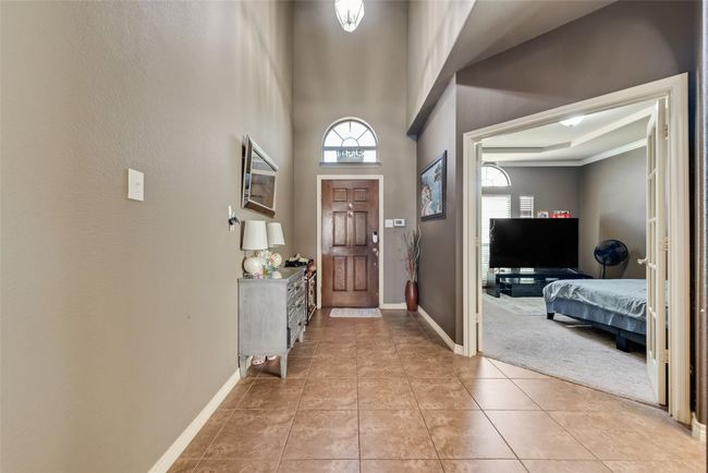 Foyer entrance with light tile patterned flooring and a high ceiling | Image 4
