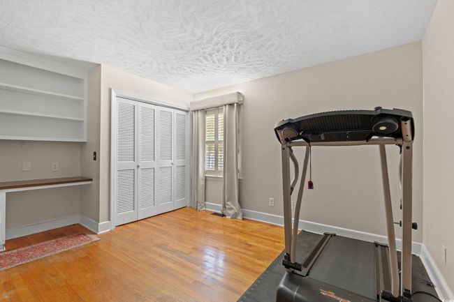 Exercise area with baseboards, wood finished floors, and a textured ceiling | Image 16