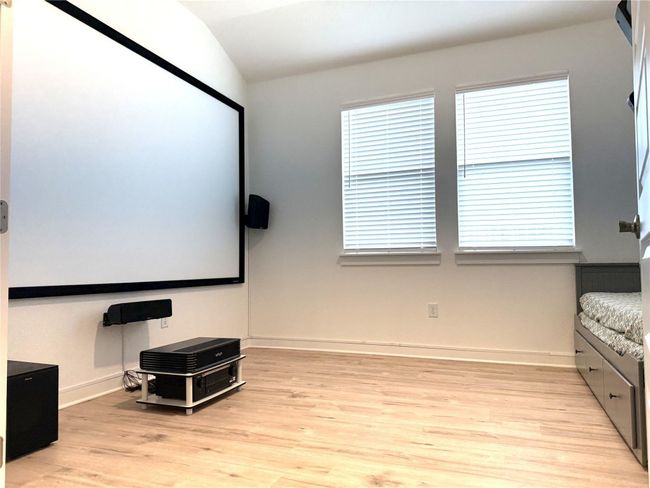 Cinema with light wood-style floors, lofted ceiling, plenty of natural light, and baseboards | Image 24