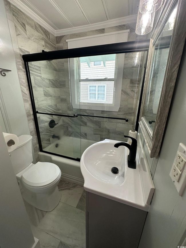 Full bathroom with vanity, crown molding, toilet, and combined bath / shower with glass door | Image 24