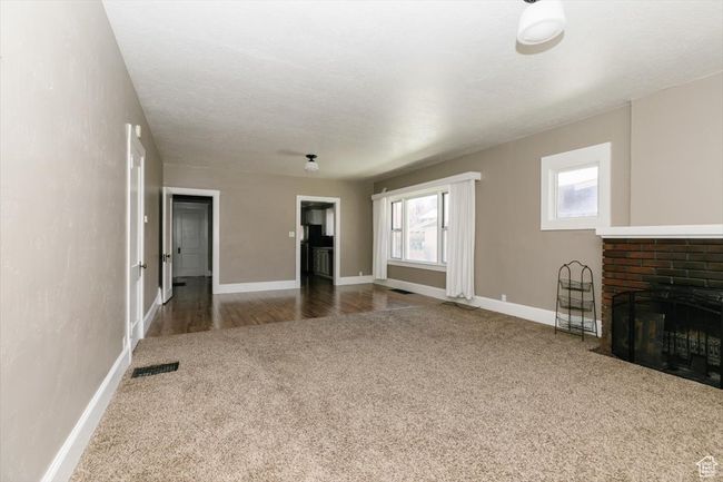Interior space featuring baseboards, a textured ceiling, and a brick fireplace | Image 6