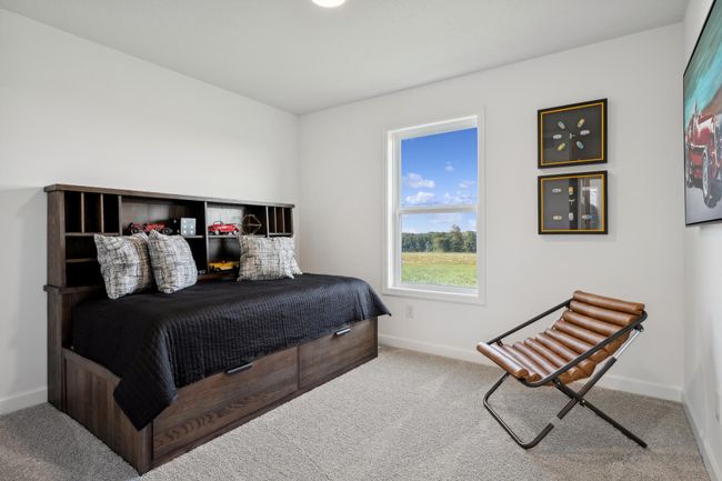 (Photo of a decorated model, actual homes finishes will vary) The second generously sized upper level secondary bedroom with a spacious closet. | Image 15