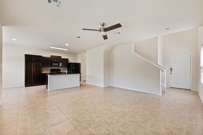 Unfurnished living room featuring ceiling fan, light tile patterned floors, stairway, recessed lighting, and baseboards | Image 14