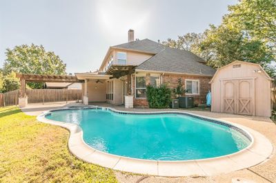 View of swimming pool with a shed, a yard, a patio, a pergola, and central AC | Image 2